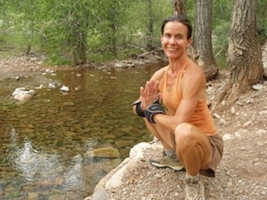 Mimi Gates meditating by a mountain stream